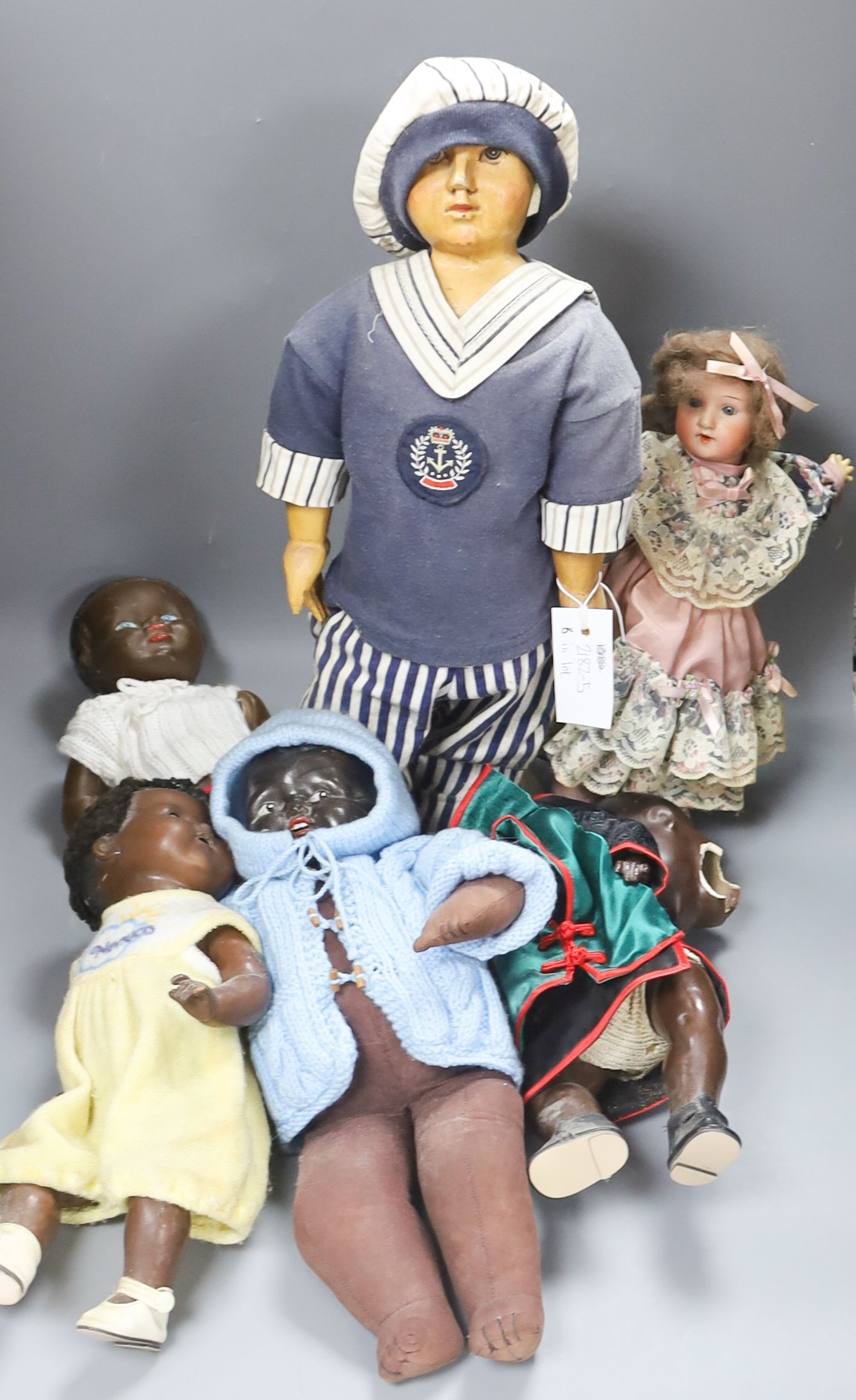 A black AM 351 cracked neck Schoneau & Hoffmeister jointed doll H13in. Black cream baby with wig crack to head H14in. two black dolls, one wood large sailor doll 20in.